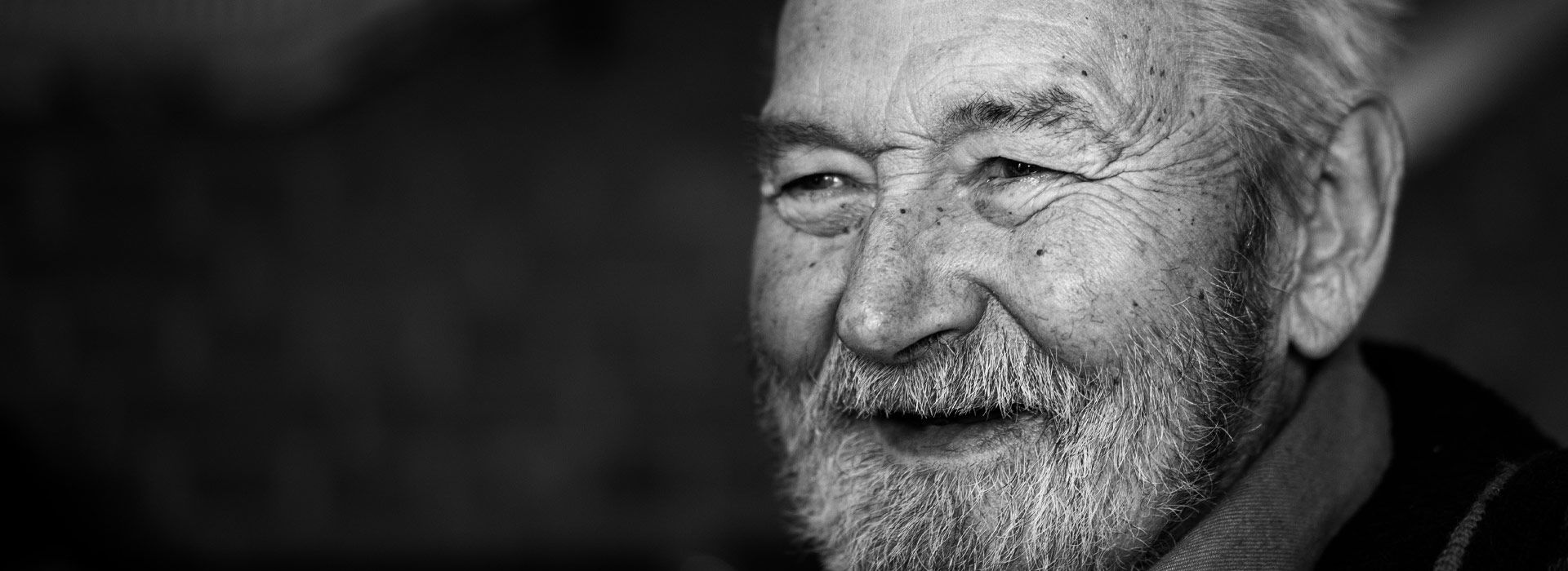 Black and white photo of a smiling elderly man